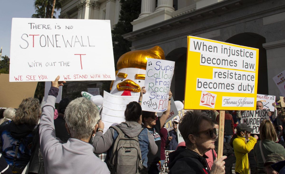 Sacramento residents held up signs and protested in the nationwide 50501 movement against the Donald Trump administration on Monday, Feb. 17, 2025, at the California State Capitol in Sacramento, Calif.