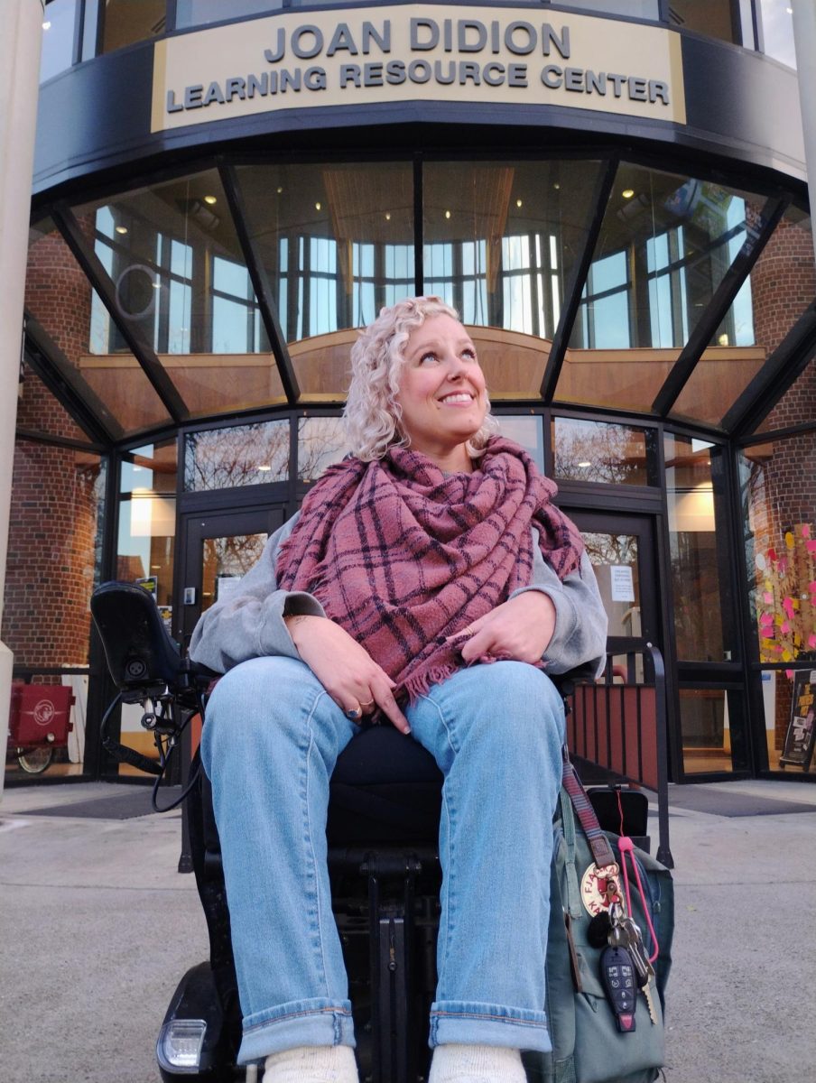 Sacramento City College WorkAbility III coordinator and DSPS counselor Rachel Stewart sits in front of the Joan Didion Learning Resource Center at Sacramento City College on Wednesday, Feb. 26, 2025, in Sacramento, Calif. Stewart is helping establish City College’s new Disability Community Center, which will be located on the first floor of the library when it opens this spring. 