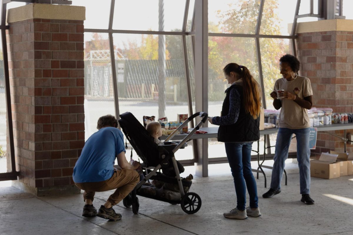 A Panther Care volunteer helps Sacramento City College students pick out food items to take home at the Panther Care Building on Wednesday, Nov. 12, 2025, in Sacramento, Calif.