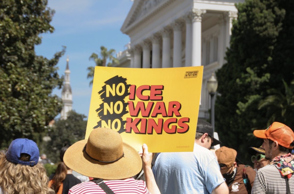 Demonstrator holds a sign at at “No Kings” rally on March 28, 2026, at the California Capitol building.